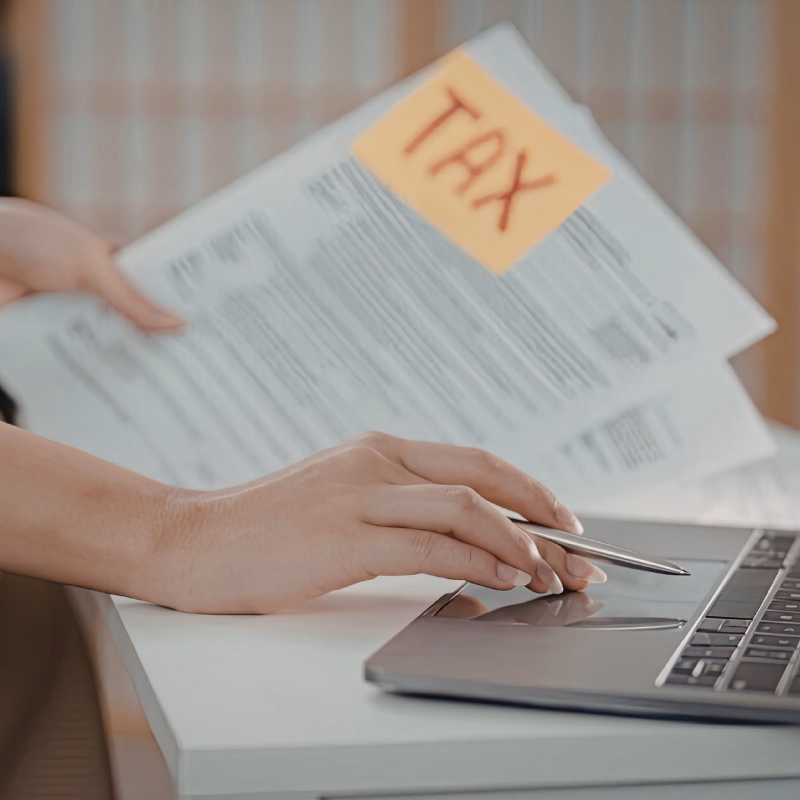 A close-up of hands reviewing a printed plan, checklist, or financial summary on a desk.