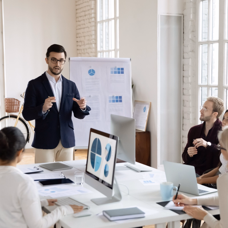 Business leader presenting financial charts to a team in a meeting, representing profit-focused leaders who use monthly bookkeeping and financial reporting to guide decisions