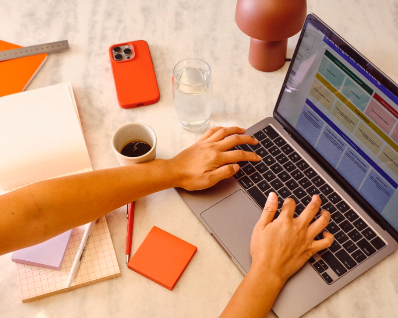 QuickBooks Online correction concept image showing marked bookkeeping worksheets, organized reports, and a desktop workstation during cleanup work